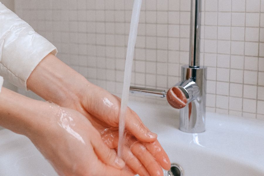 una mujer se lava las manos